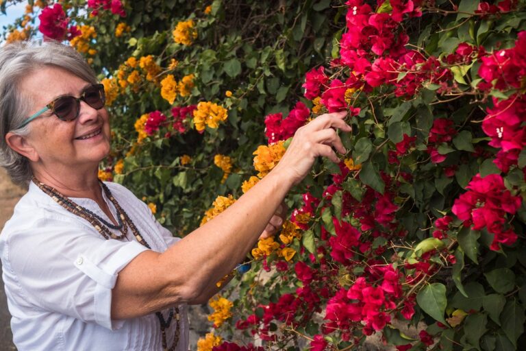 elderly woman looking and feeling pretty flowers